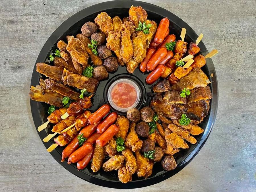 Round meaty platter with wings, chicken strips, meatballs, chicken kebabs and cocktail sausages around a dipping sauce