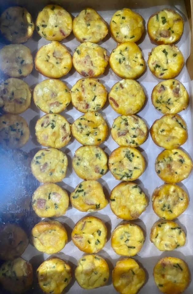 A tray of mini quiches with bacon and chives