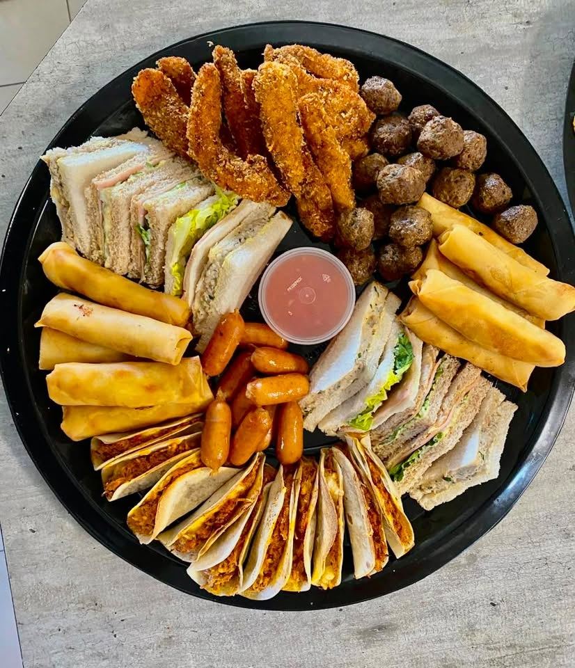Mixed platter with sandwiches, chicken strips, meatballs, spring rolls, cocktail sausages and mini tacos